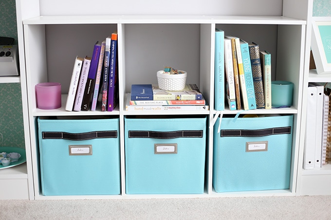 Cube unit holding fabric bins and books in an organized home office