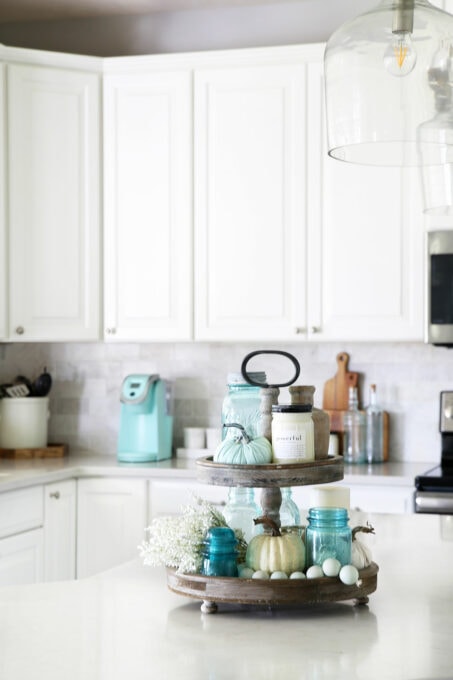 Tiered tray on kitchen counter with aqua and white fall decor