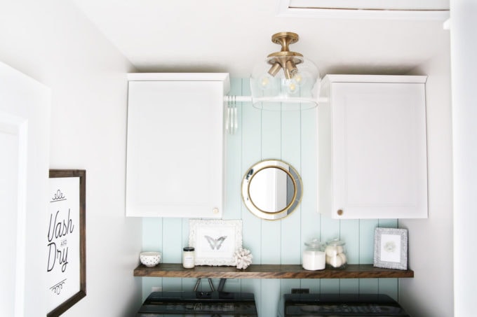 Small Laundry Room Organized with Two Cabinets and Shelf Above the Washer and Dryer