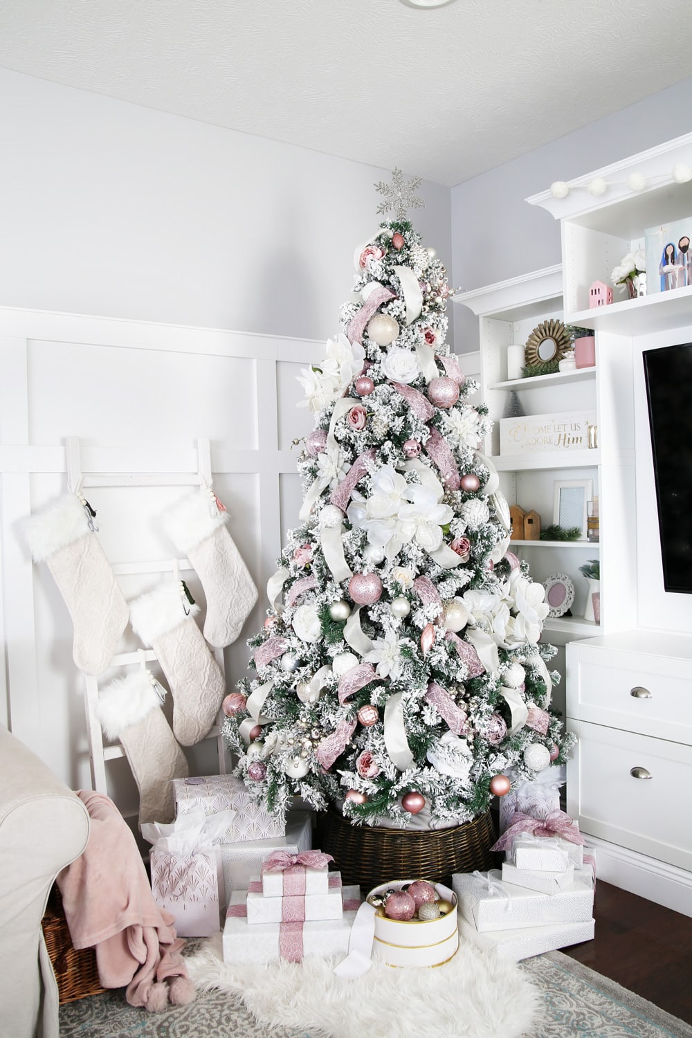 Flocked Christmas tree with pink ornaments and pink ribbon