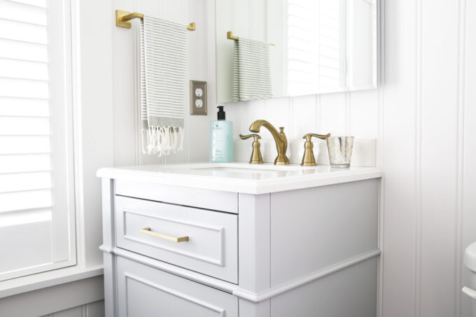 Brass Towel Holder and Sink Faucet in a Beautifully Decorated Half Bathroom