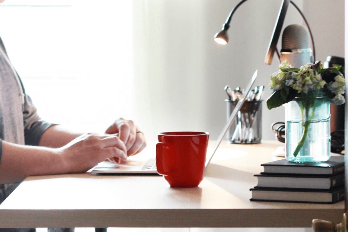 Man Working on a Laptop Computer with a Coffee Mug Sitting Next to It