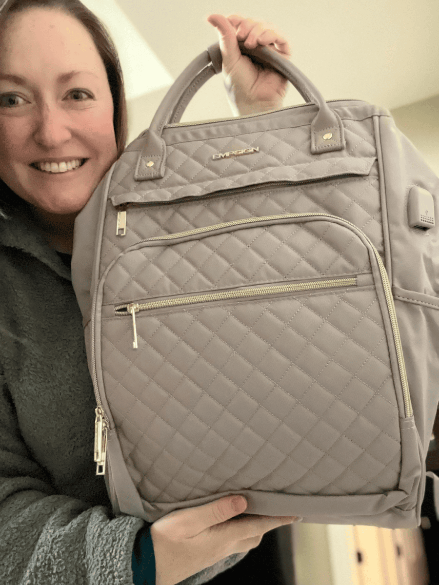 Smiling woman holding a travel backpack