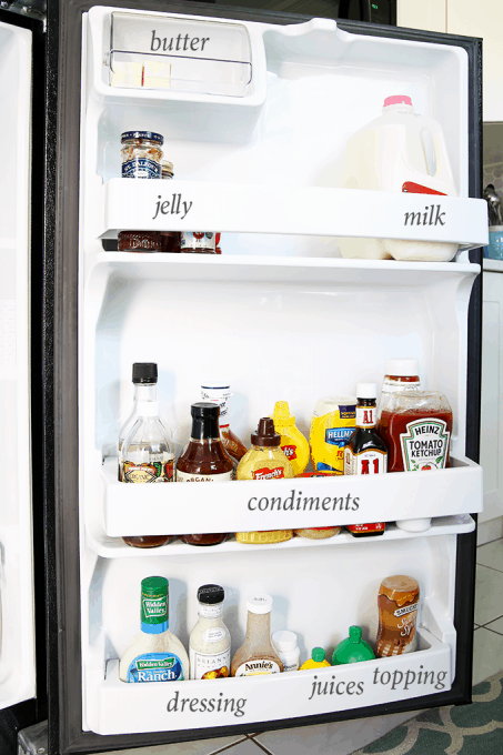 a small refrigerator with the door open showing the organized condiments with text overlay labels