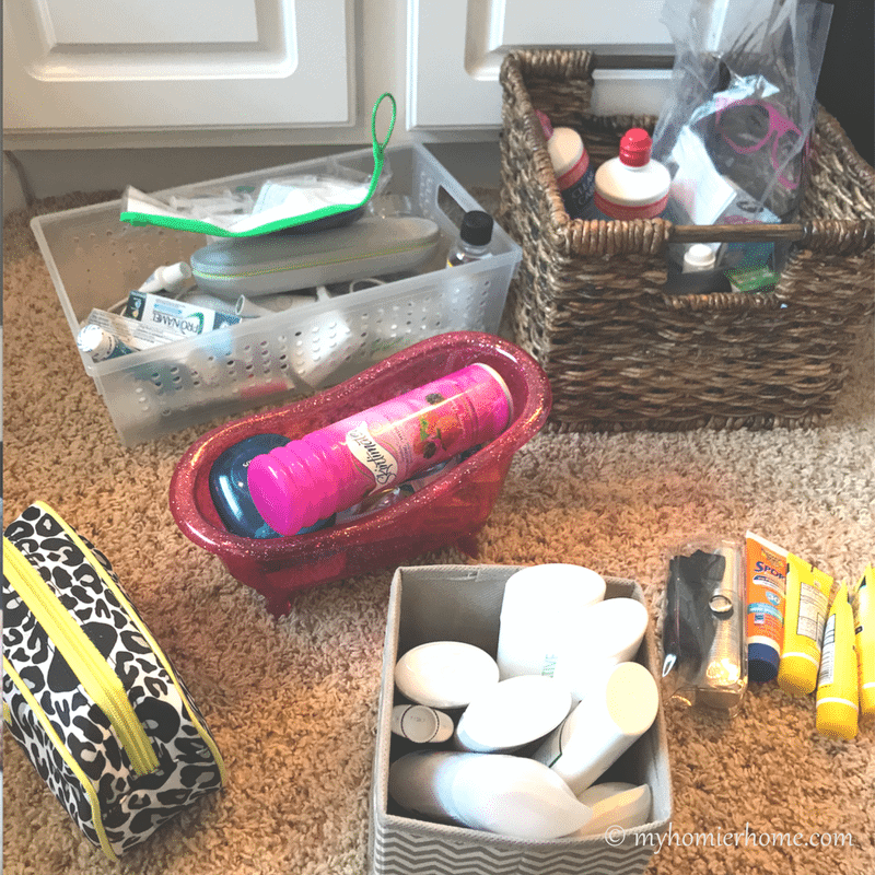 Bathroom items grouped on the floor from under the bathroom sink from My Homier Home